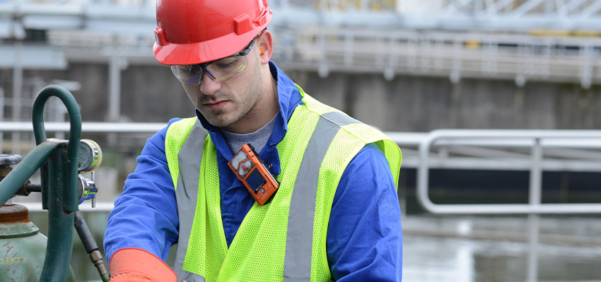 Lone worker at water treatment facility wearing Industrial Scientific VentisPro 5 gas monitoring device